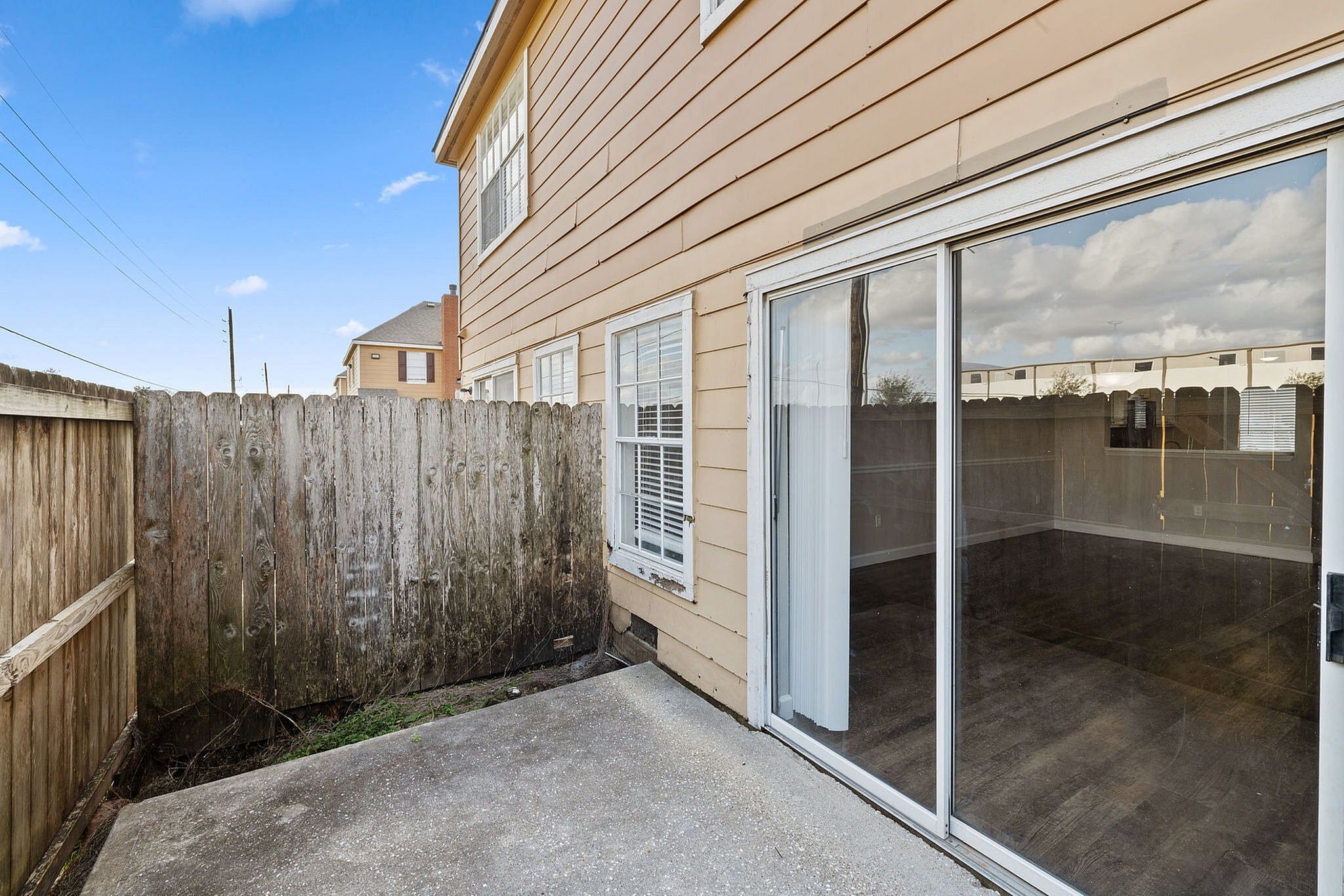 Charming outdoor patio with large sliding glass doors leading to a cozy, sunlit living space.