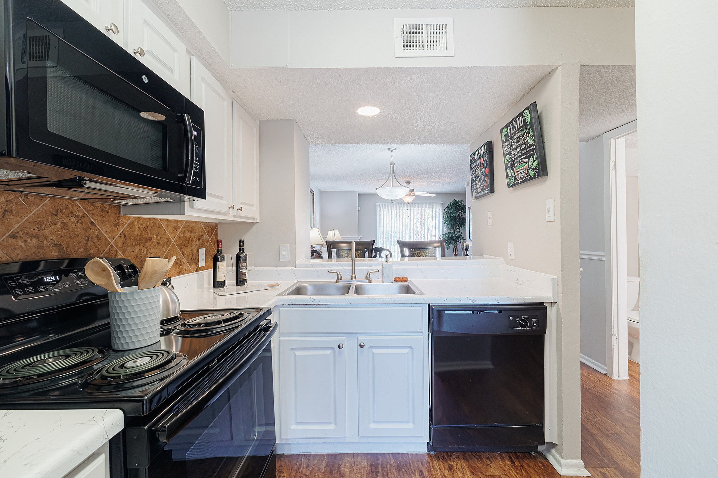 Bright and inviting kitchen with modern appliances, elegant countertops, and a glimpse into a cozy dining area.