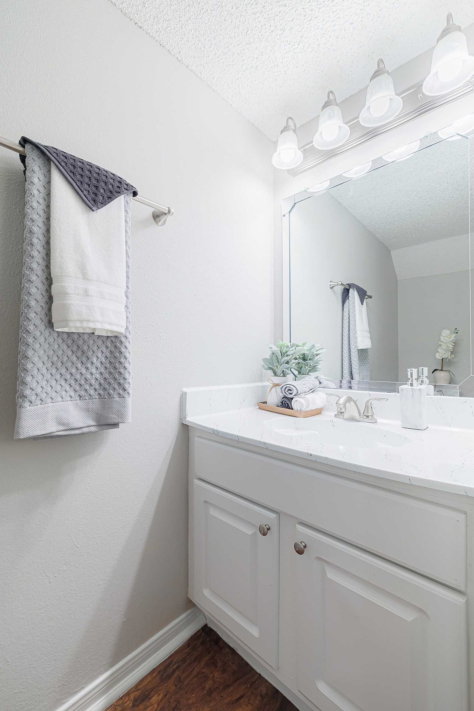 Bright and modern bathroom with elegant vanity, large mirror, and soft lighting creating a cozy ambiance.