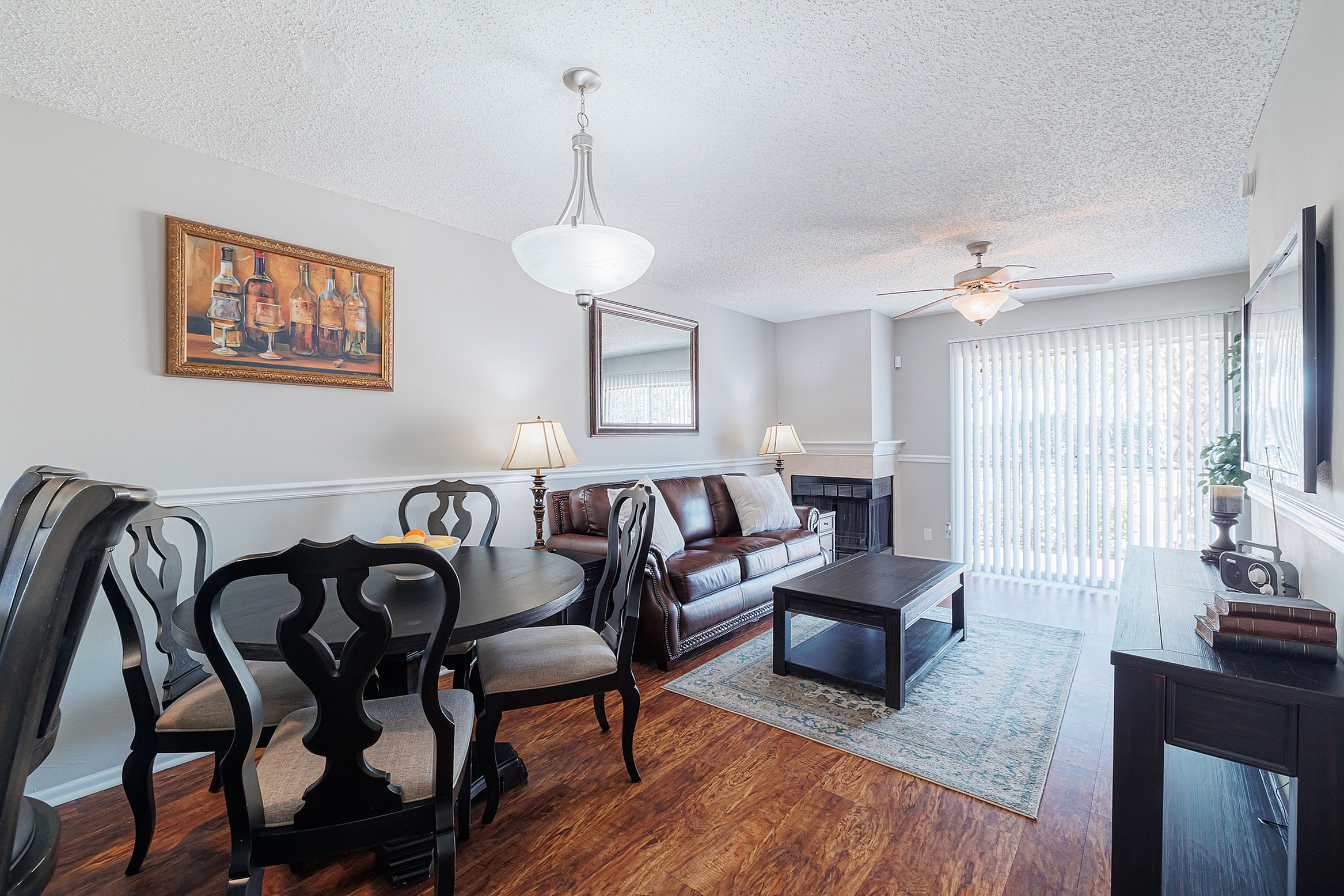 Charming open-plan living and dining area with stylish furniture, elegant lighting, and abundant natural light from large windows.