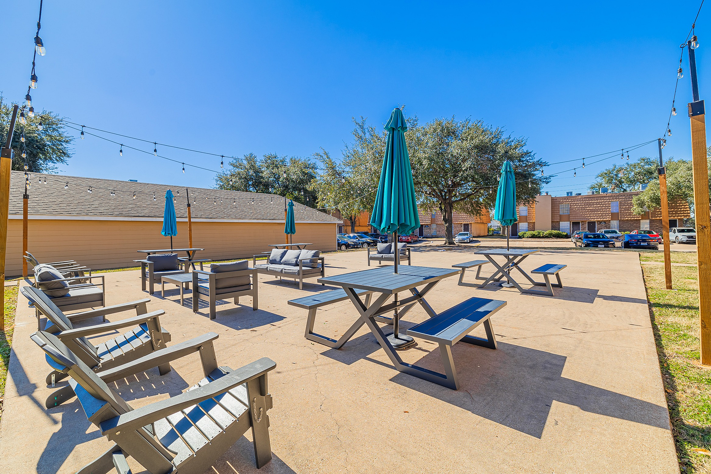 Charming outdoor patio with stylish seating, vibrant umbrellas, and enchanting string lights, perfect for relaxation and gatherings.
