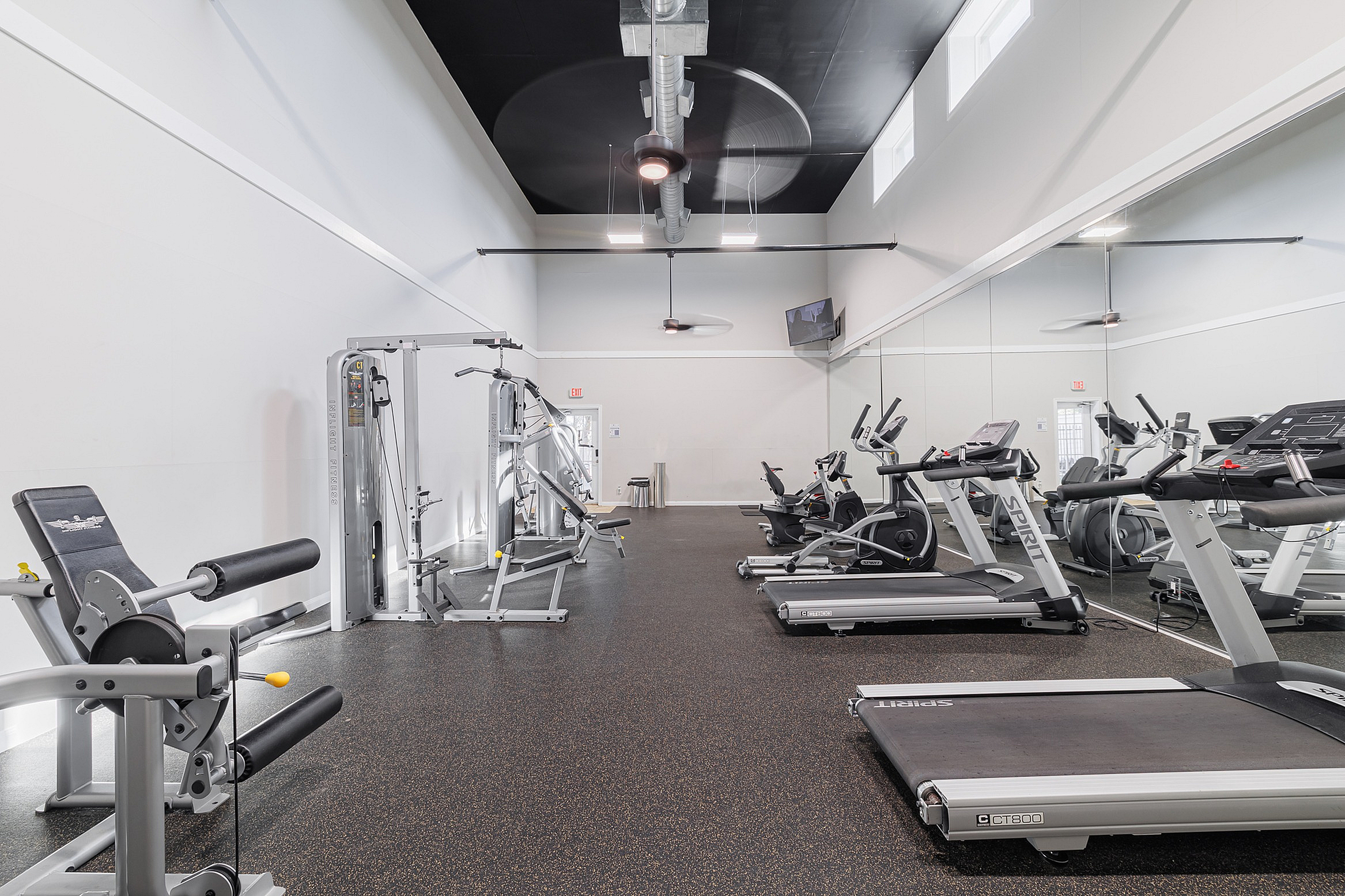 Modern fitness center featuring sleek treadmills, versatile weight machines, and a spacious design.