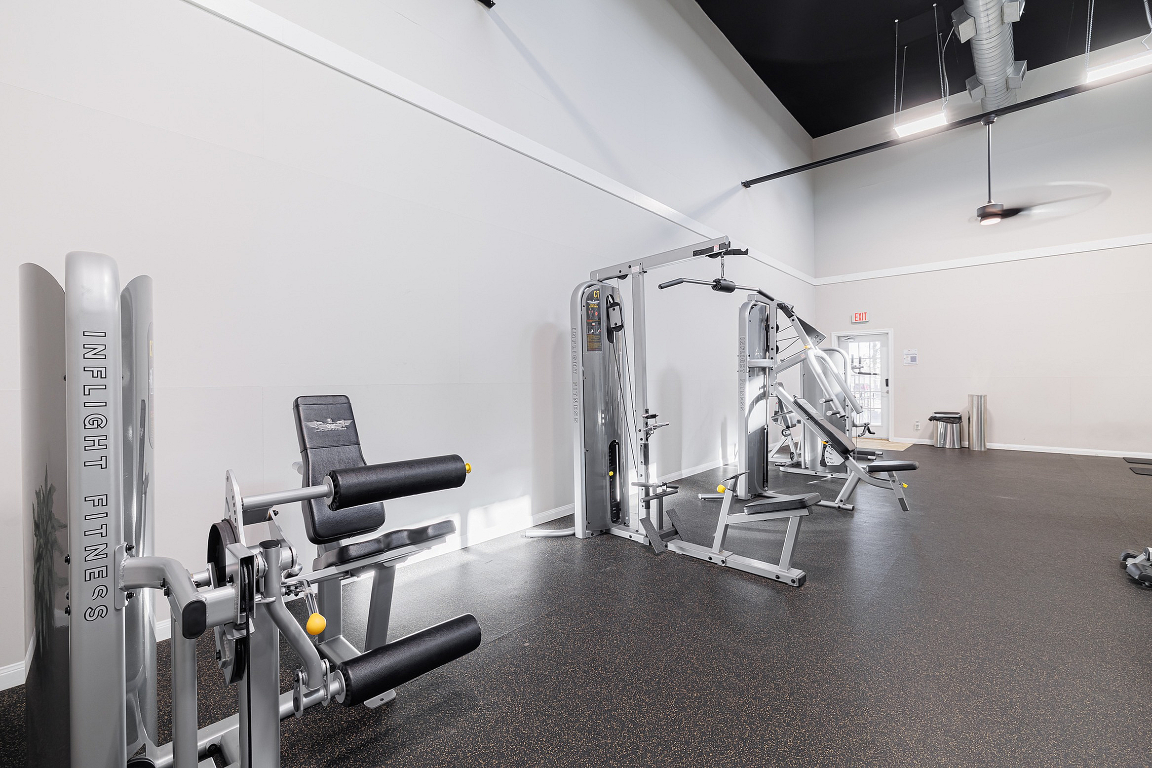 Modern and spacious gym with state-of-the-art fitness equipment and high ceilings, perfect for an invigorating workout.