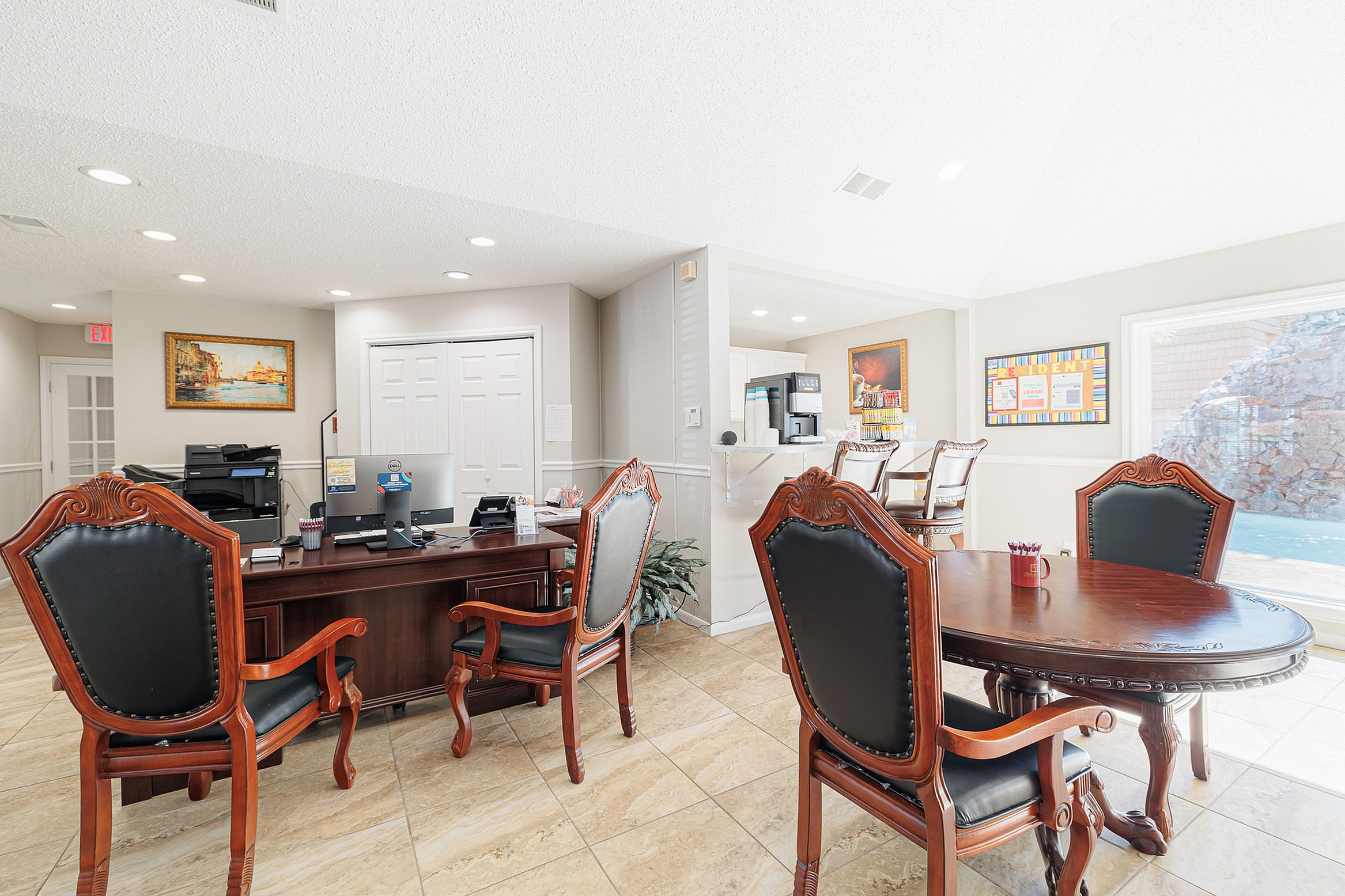 Elegant office space with classic wooden furniture, featuring a spacious desk, comfortable seating, and a view of the pool.