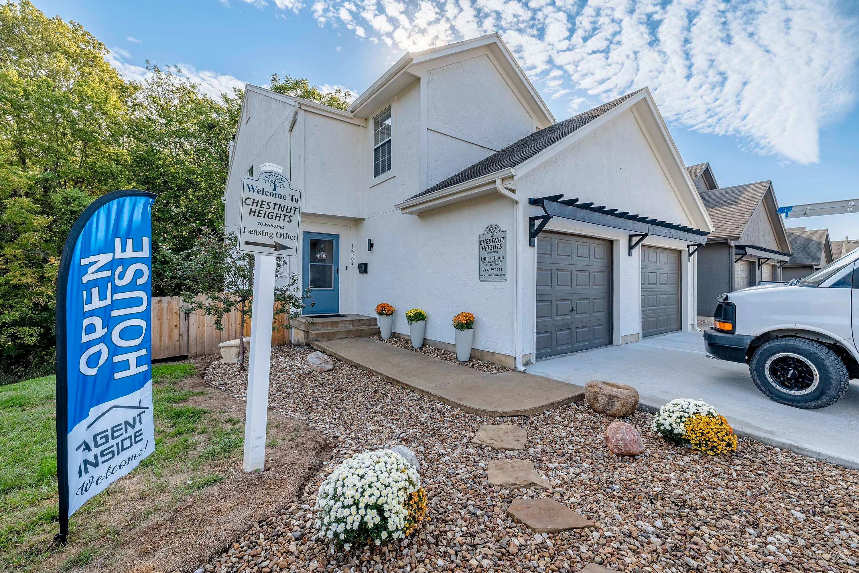 Welcoming townhome entrance at Chestnut Heights with open house sign, lush greenery, and elegant exterior design.