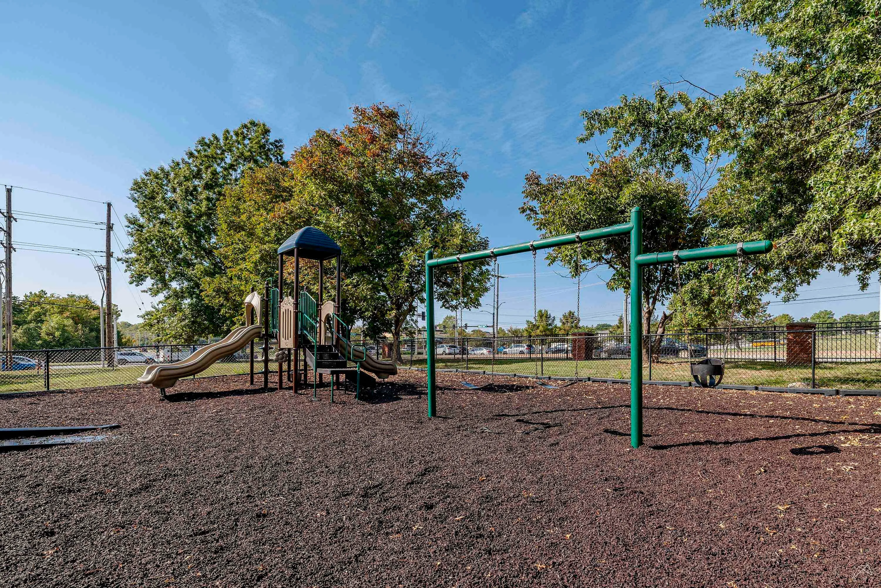 Inviting playground with modern slides and swings surrounded by lush greenery, perfect for family fun.