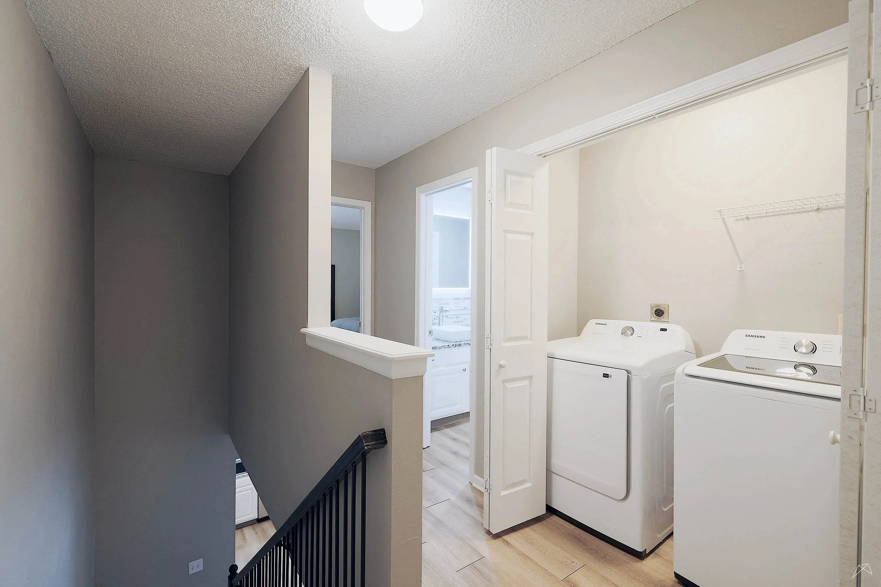 Chic apartment hallway featuring a convenient in-unit laundry area with modern Samsung washer and dryer.