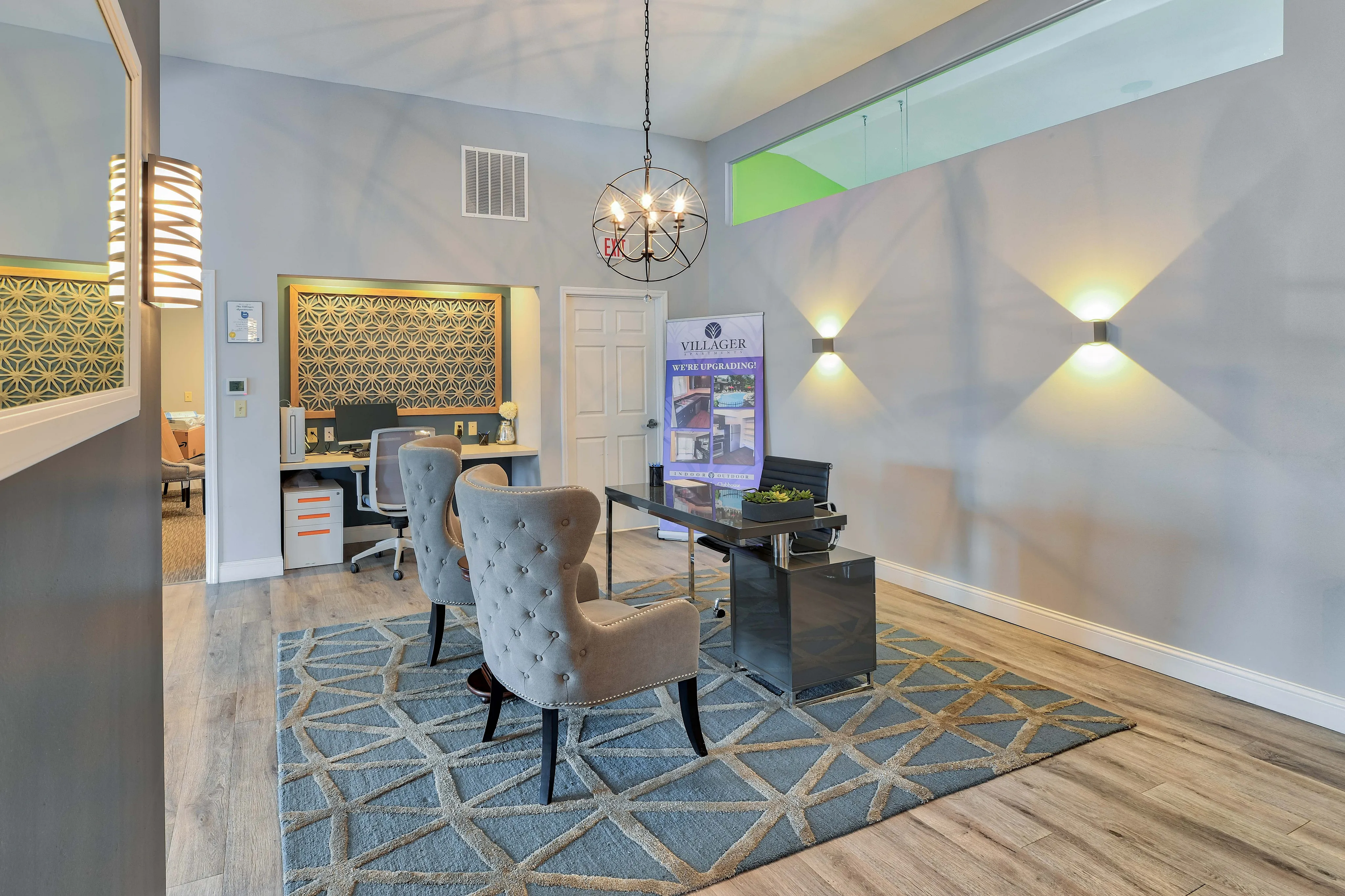 Elegant office space with plush seating, geometric-patterned walls, and stylish lighting fixtures, ideal for a professional setting.