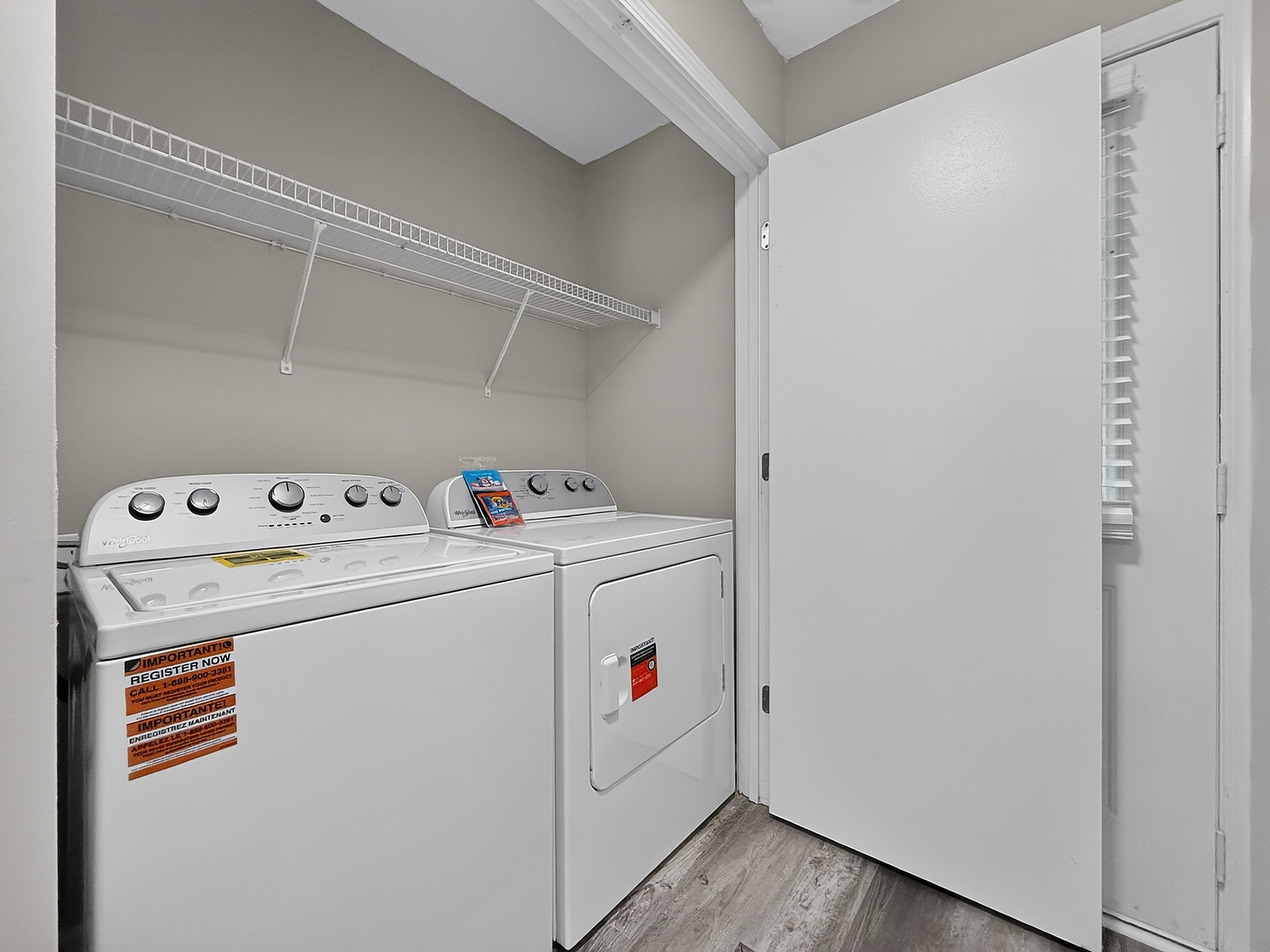Modern laundry room featuring top-of-the-line washer and dryer with ample shelving, styled in a sleek, minimalistic design.