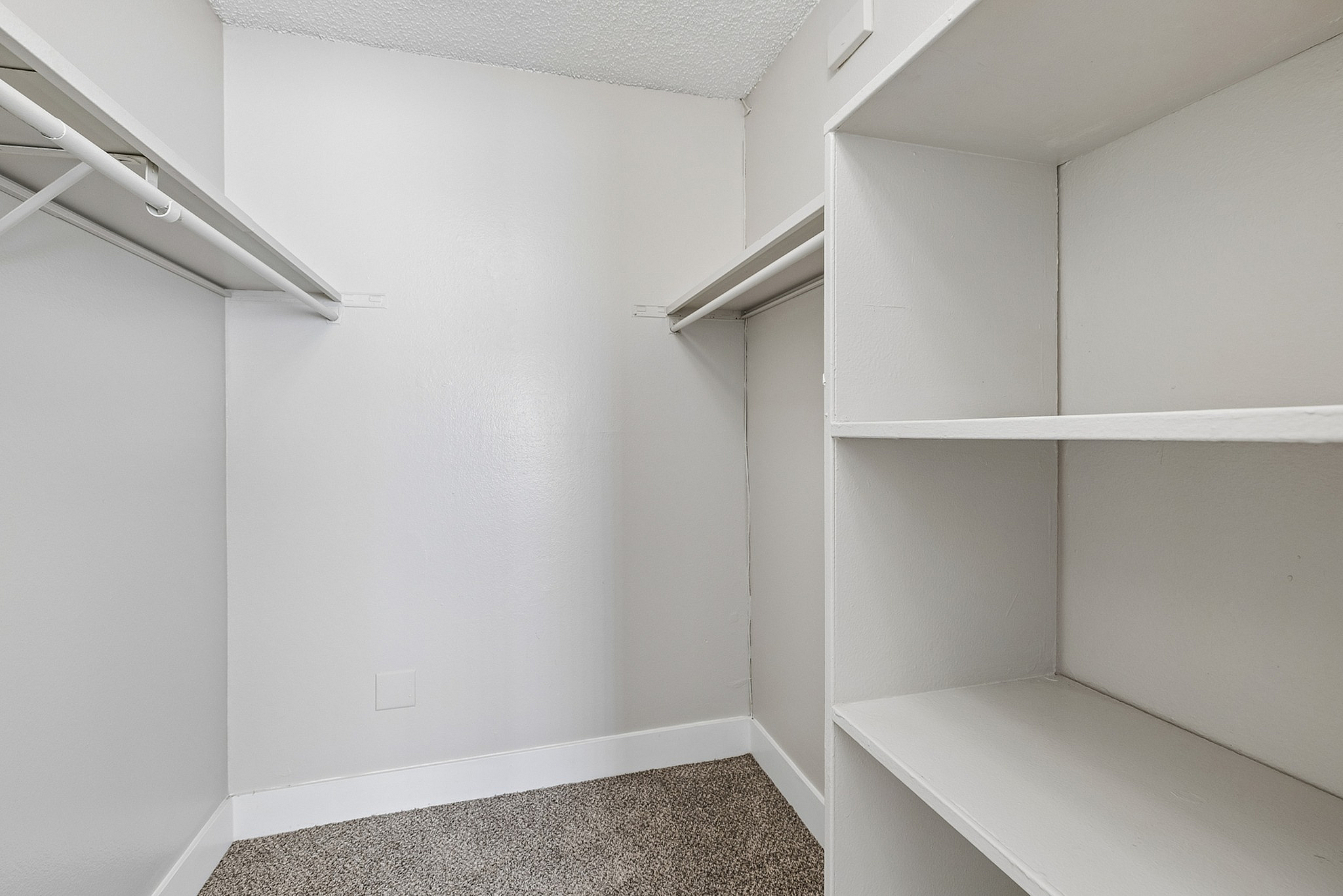 Spacious walk-in closet with ample shelving and hanging space, perfect for organized living.