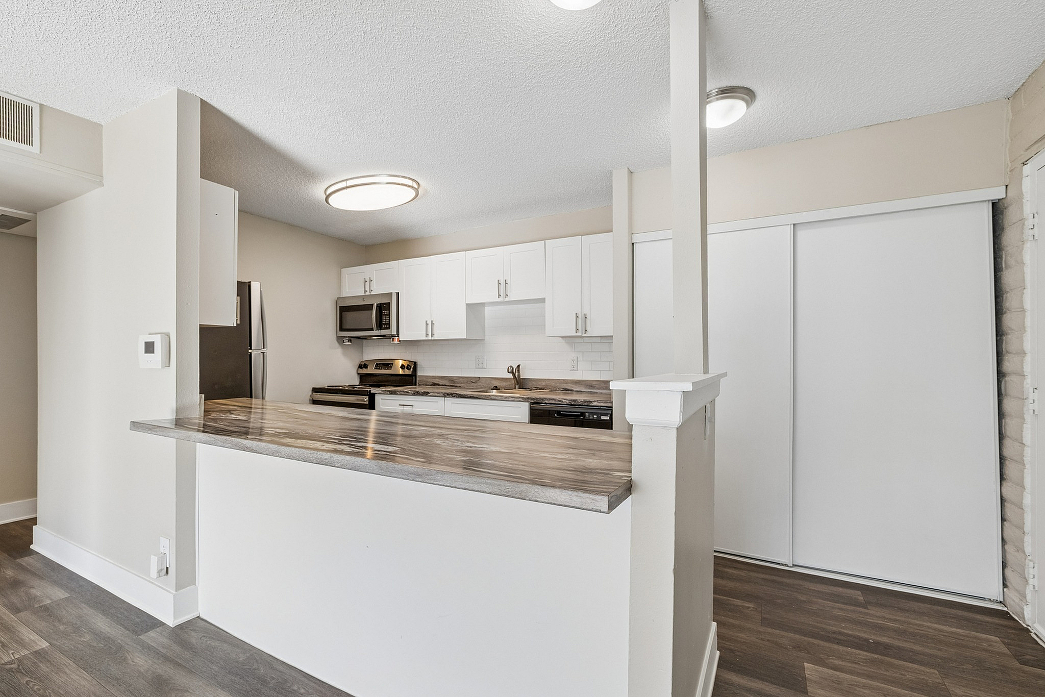 Modern kitchen with sleek countertops, stainless steel appliances, and elegant white cabinetry, perfect for culinary enthusiasts.