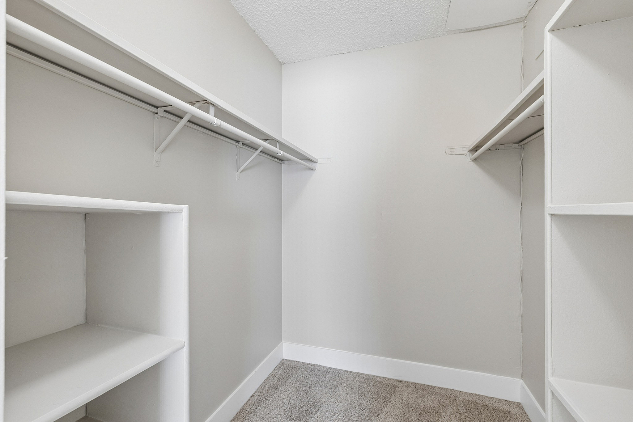 Spacious walk-in closet with ample shelving and a sleek design, perfect for organized storage.