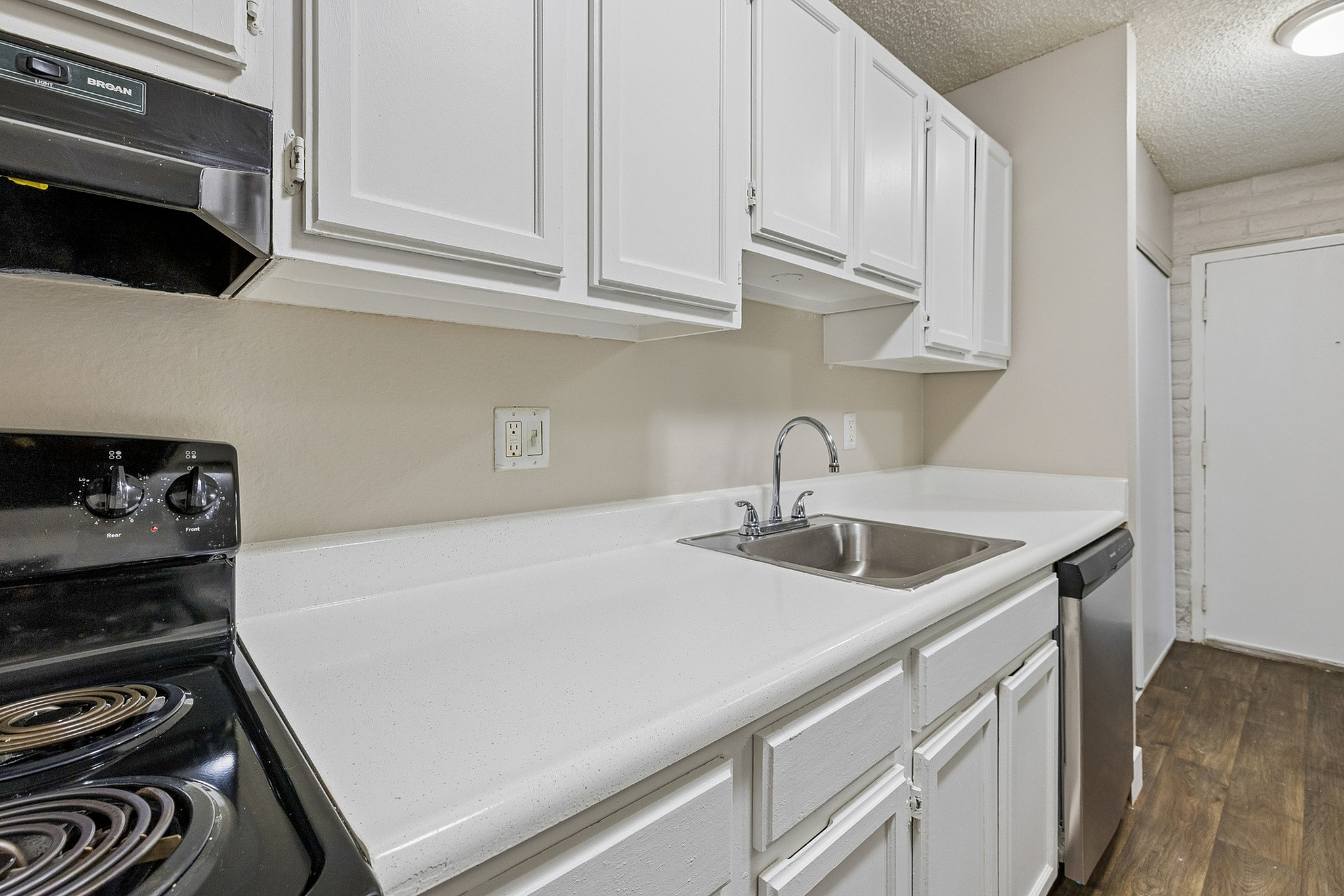 Modern kitchen with sleek white cabinetry, polished countertops, and stainless steel appliances.