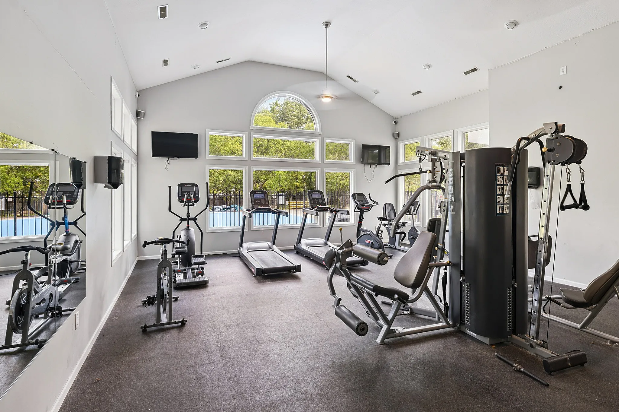 Modern fitness center with state-of-the-art exercise equipment and large windows offering scenic outdoor views.