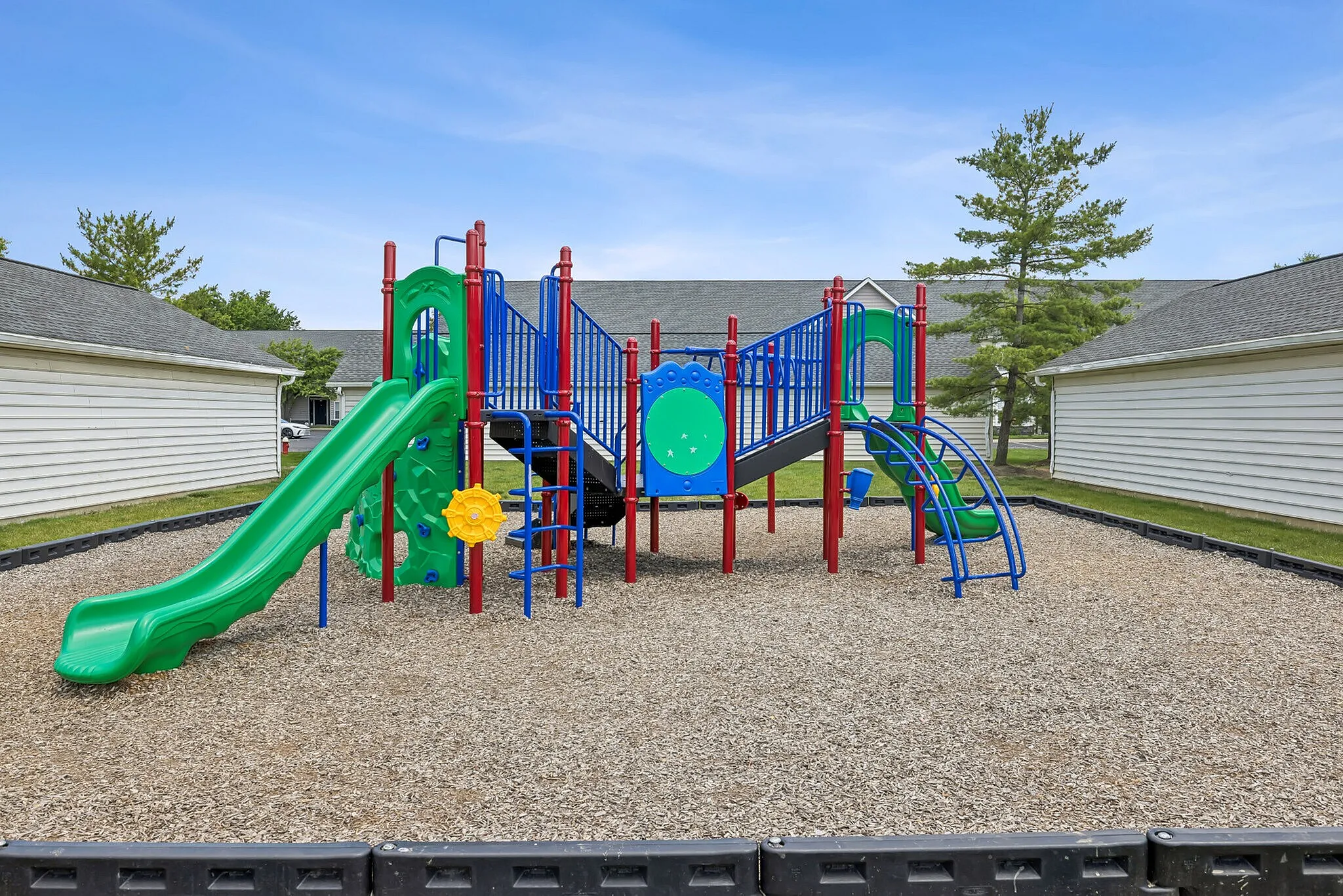 Vibrant playground with colorful slides and climbing structures, perfect for family fun in the backyard.