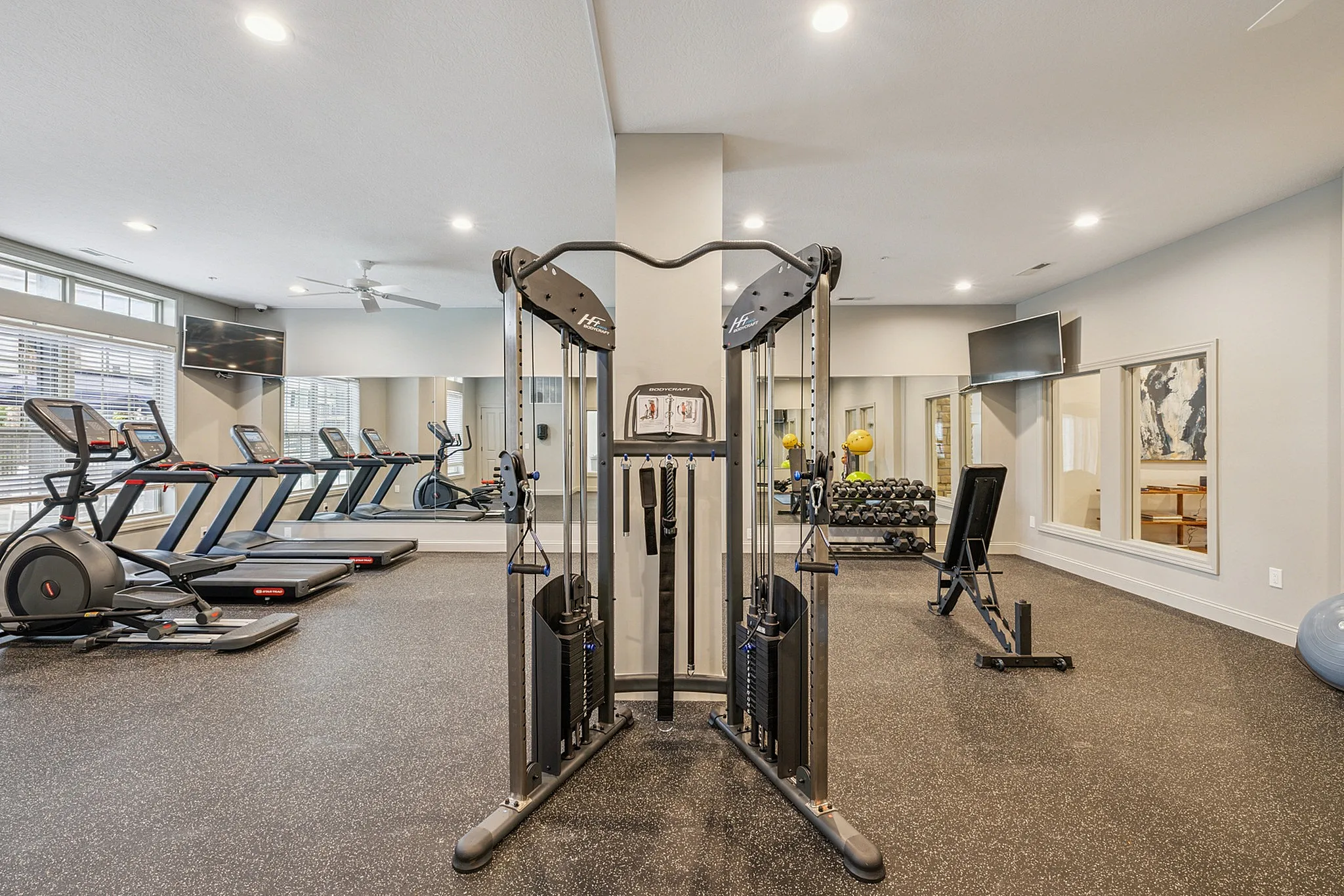 Modern fitness center with state-of-the-art cardio machines, weight stations, and a sleek design for an energizing workout experience.