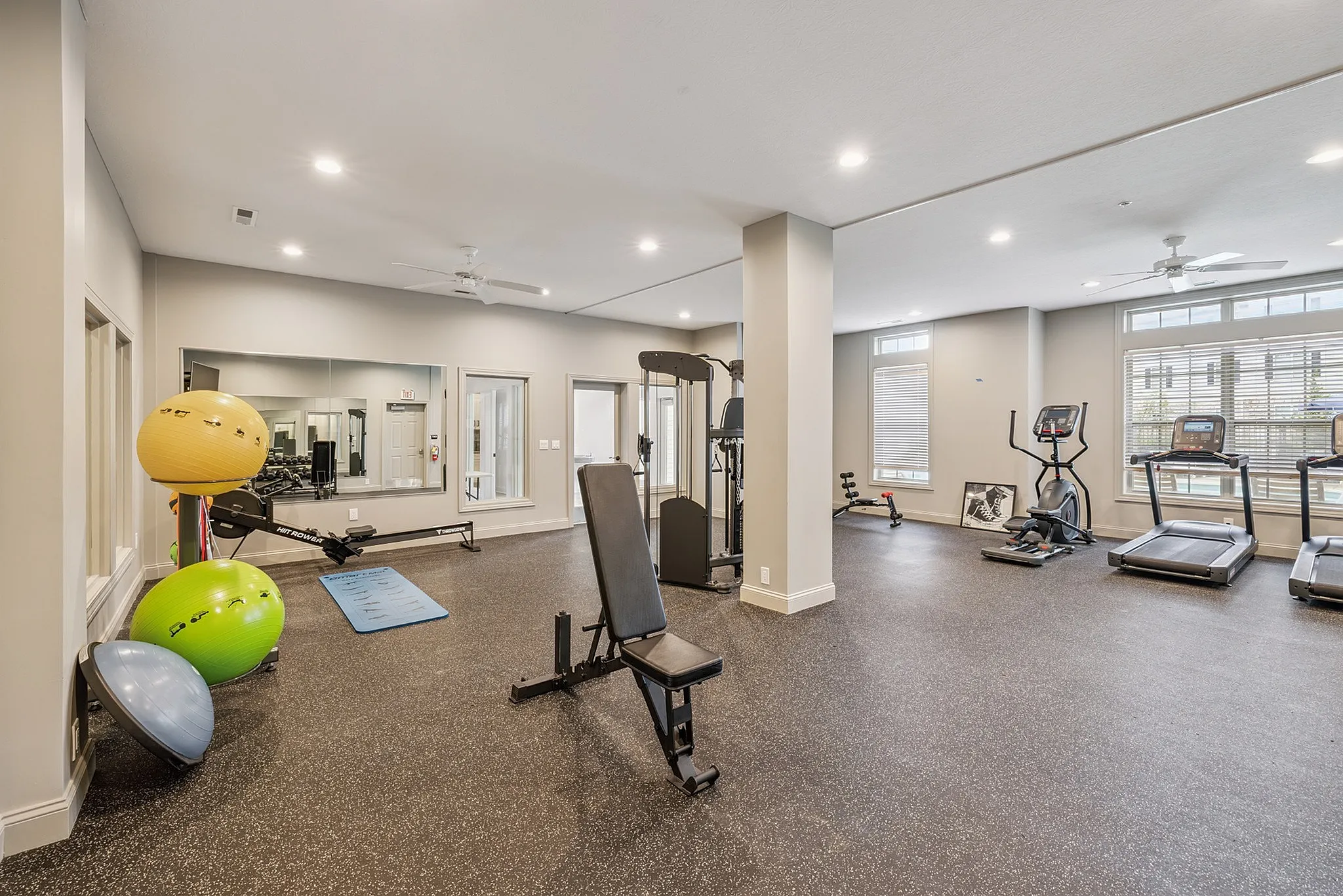 Modern fitness center with state-of-the-art cardio machines, weight equipment, and exercise balls for a complete workout experience.