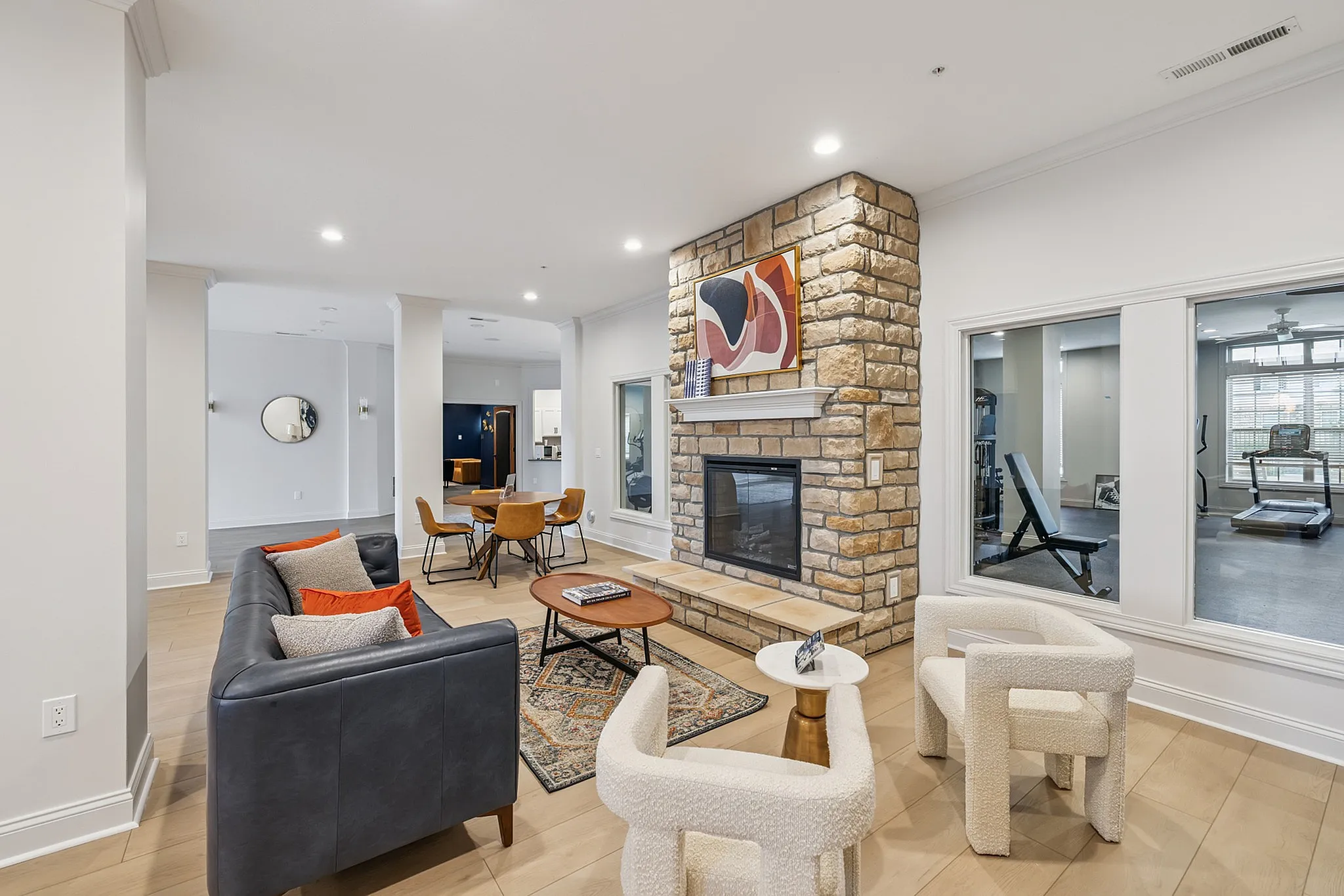 Elegant living space showcasing a cozy stone fireplace, modern furniture, and an open layout perfect for relaxation and entertainment.