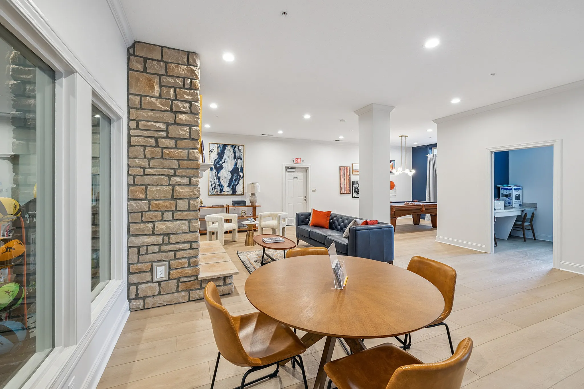 Elegant open-concept living space featuring a cozy seating area, stylish dining table, and modern pool table, perfect for relaxation and entertainment.