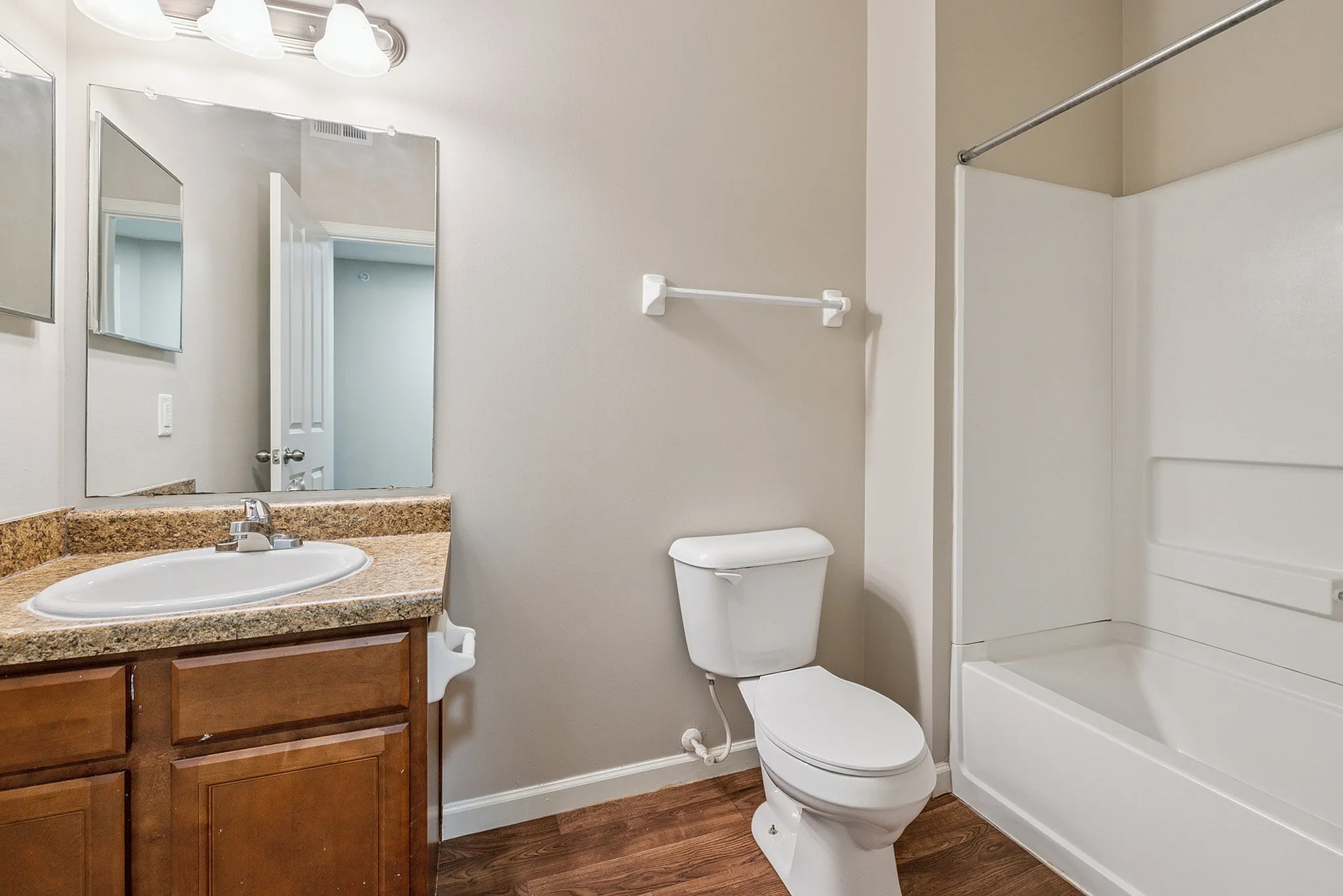 Inviting bathroom with elegant granite countertop, modern fixtures, and a pristine bathtub.