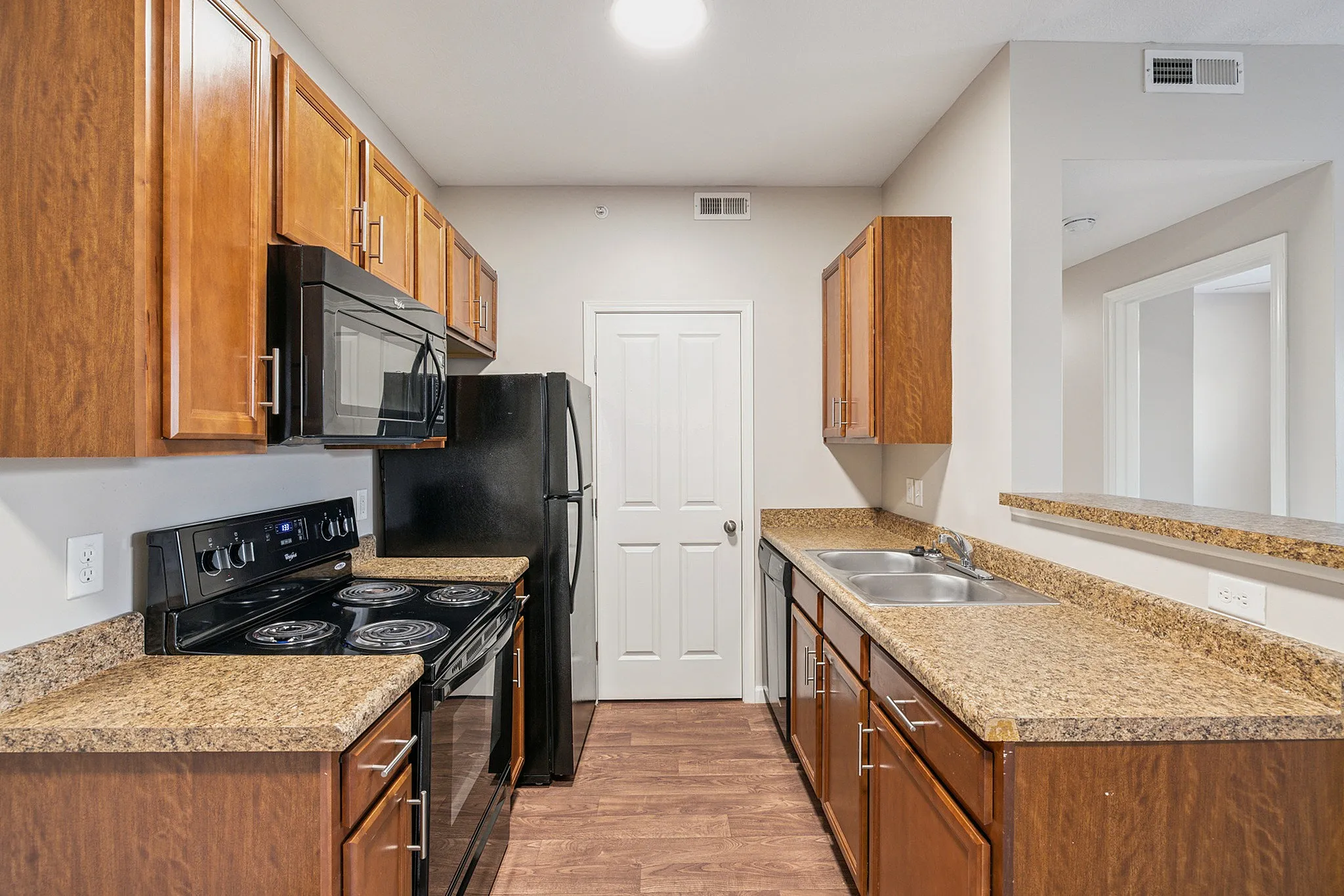 Modern kitchen with elegant wooden cabinetry, sleek black appliances, and ample counter space for culinary enthusiasts.