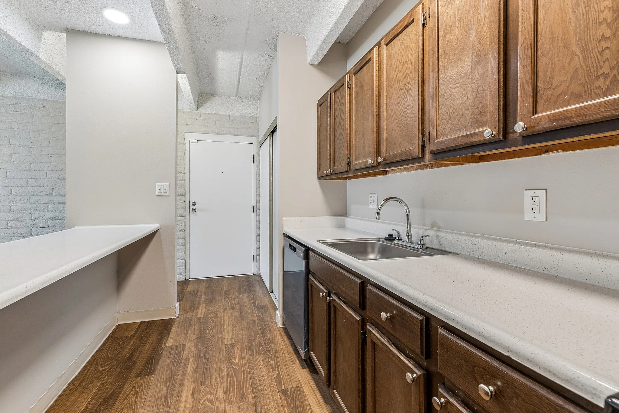 Charming kitchen with sleek wooden cabinets, modern countertops, and warm wood flooring, perfect for culinary adventures.