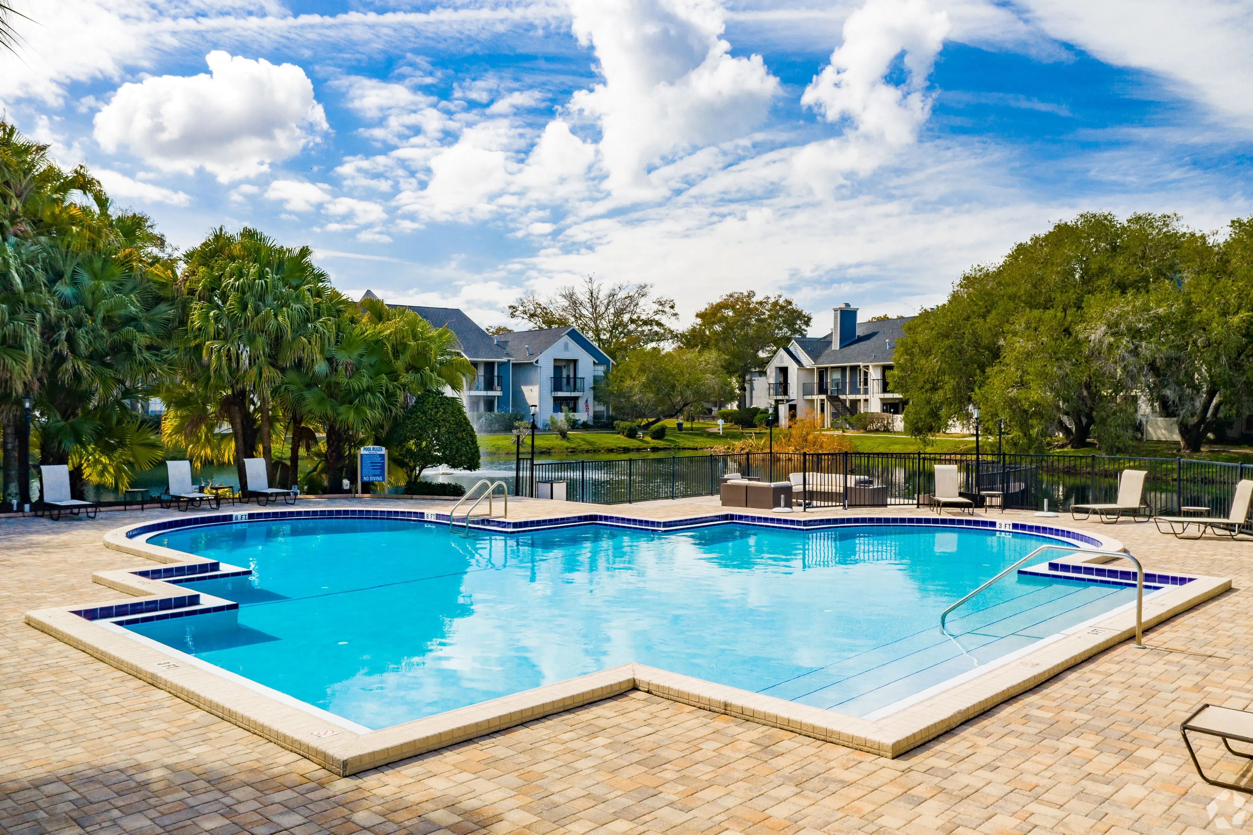Inviting residential community with a pristine pool, lush greenery, and stylish apartments in a tranquil setting.