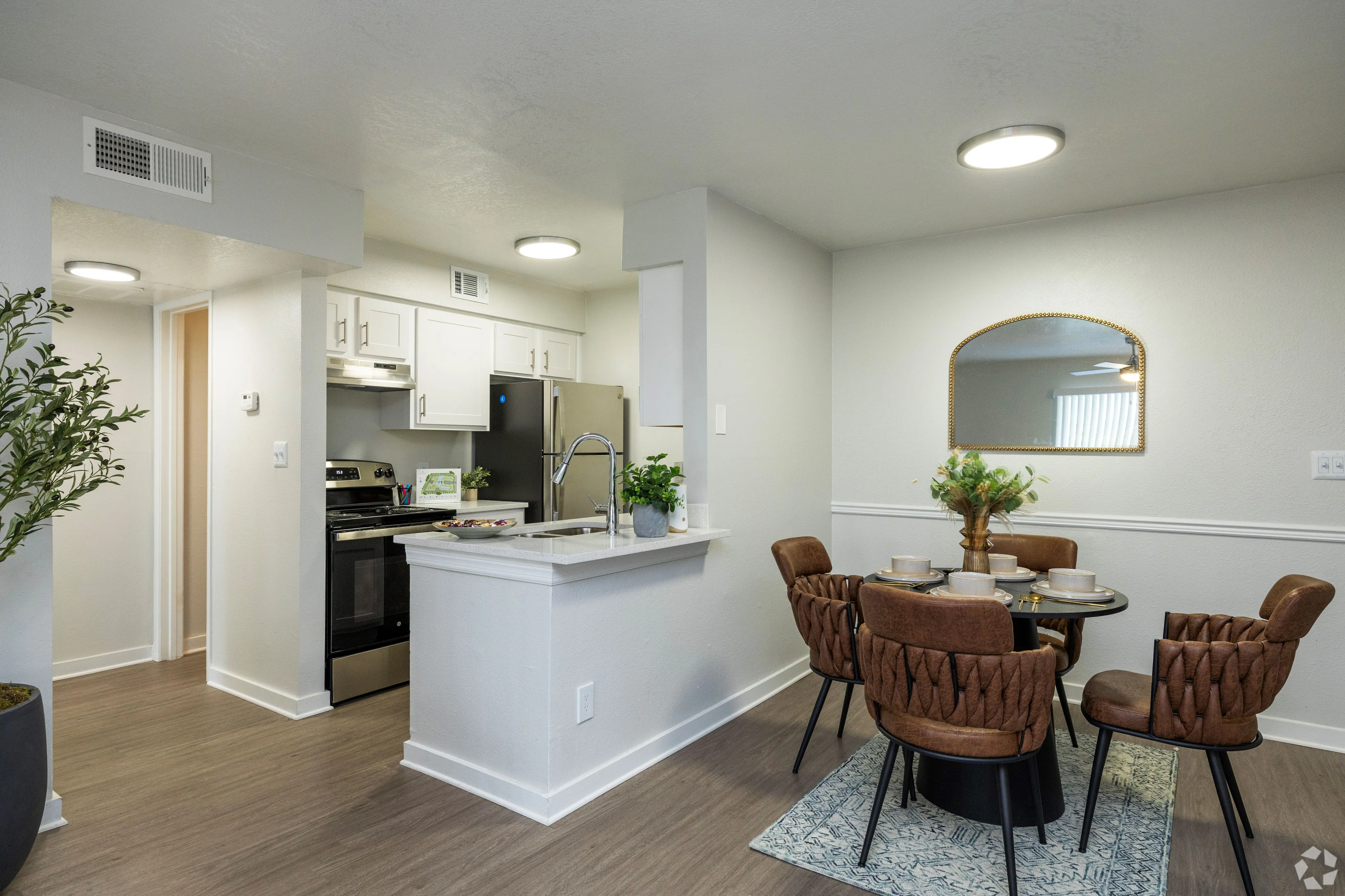 Modern kitchen and dining area with stylish cabinetry, stainless steel appliances, and an elegant dining set, exuding a warm and inviting ambiance.