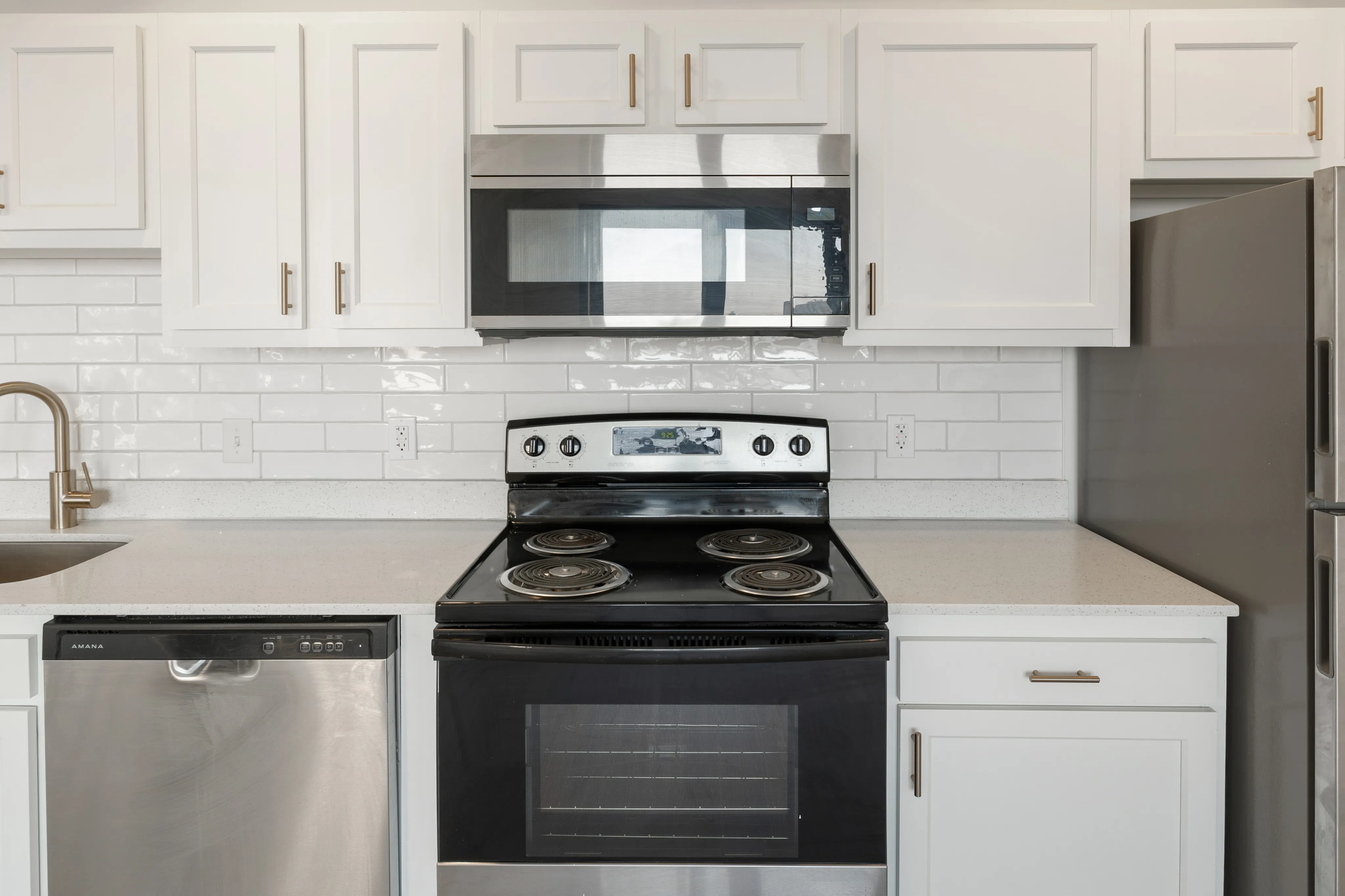 Modern kitchen featuring sleek stainless steel appliances, elegant white cabinetry, and a stylish subway tile backsplash.