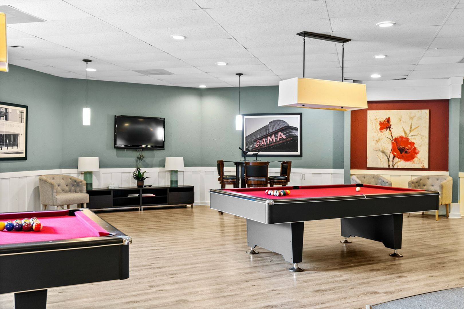 Chic recreational lounge featuring a vibrant red pool table, modern decor, and cozy seating area for entertainment.