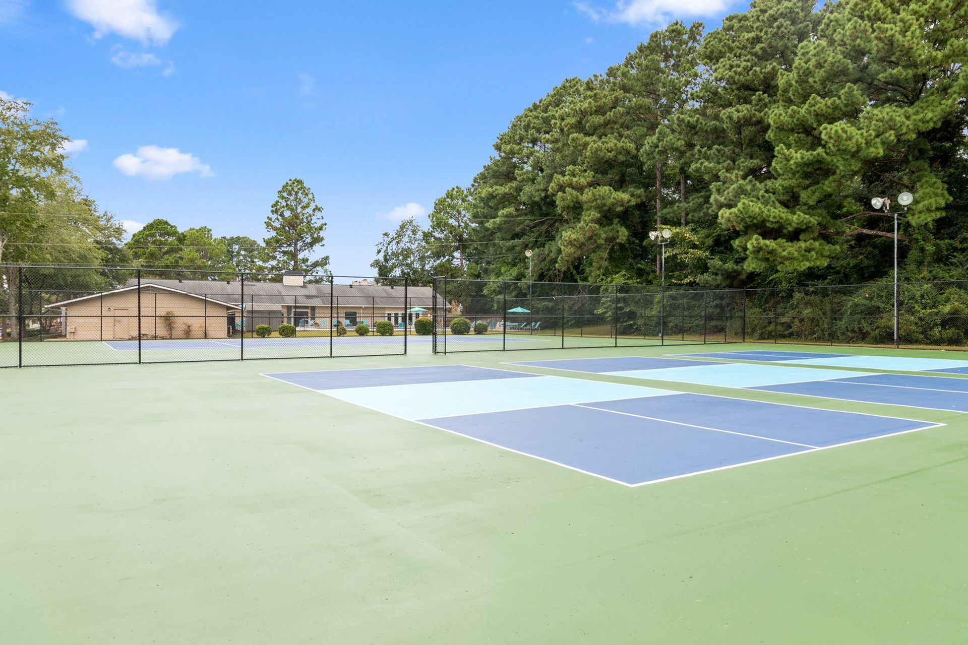 Vibrant tennis courts surrounded by lush greenery, perfect for active outdoor living.
