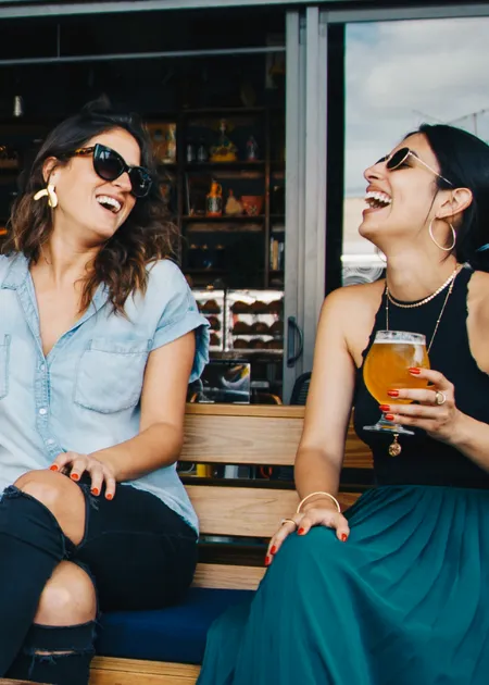 stock image - two women sitting on a bench laughing Venue Museum District