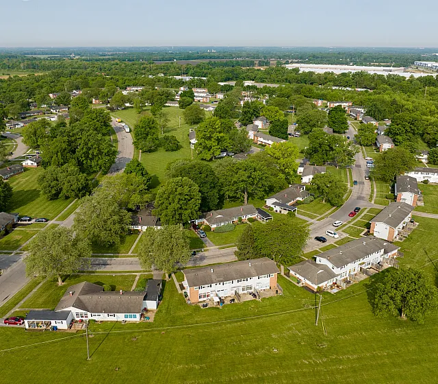Aerial view of a lush suburban neighborhood with tree-lined streets and spacious homes.