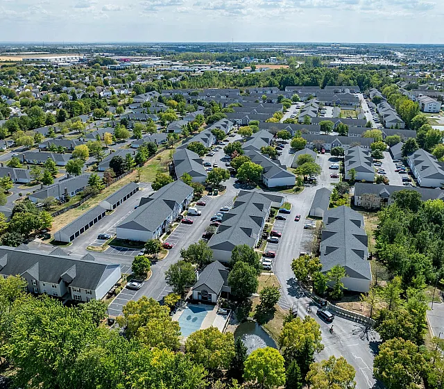 Aerial view of a serene residential community surrounded by lush greenery and well-planned roads.