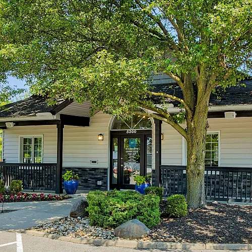 Inviting clubhouse surrounded by lush greenery and vibrant landscaping.
