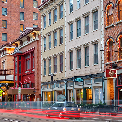 Vibrant urban street lined with charming historic buildings and colorful storefronts at dusk.