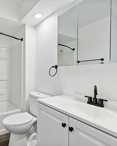 Sleek modern bathroom with elegant black fixtures, a pristine bathtub, and ample cabinetry for stylish living.