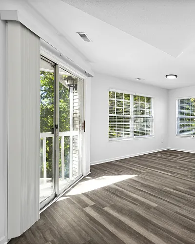 Bright, contemporary living space with sleek hardwood floors, abundant natural light, and a modern open-concept kitchen.