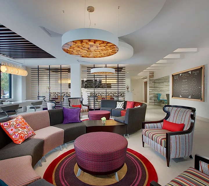 Vibrant and modern communal lounge with stylish seating, colorful cushions, and chic lighting, perfect for relaxation and social gatherings.