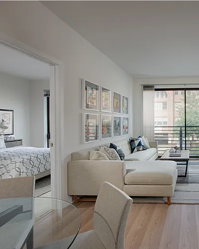 Modern living room with chic decor and large windows offering abundant natural light, connected to cozy bedrooms for a harmonious living space.