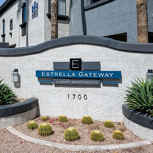 Inviting entrance sign for Estrella Gateway Luxury Apartments surrounded by lush greenery and modern design elements.