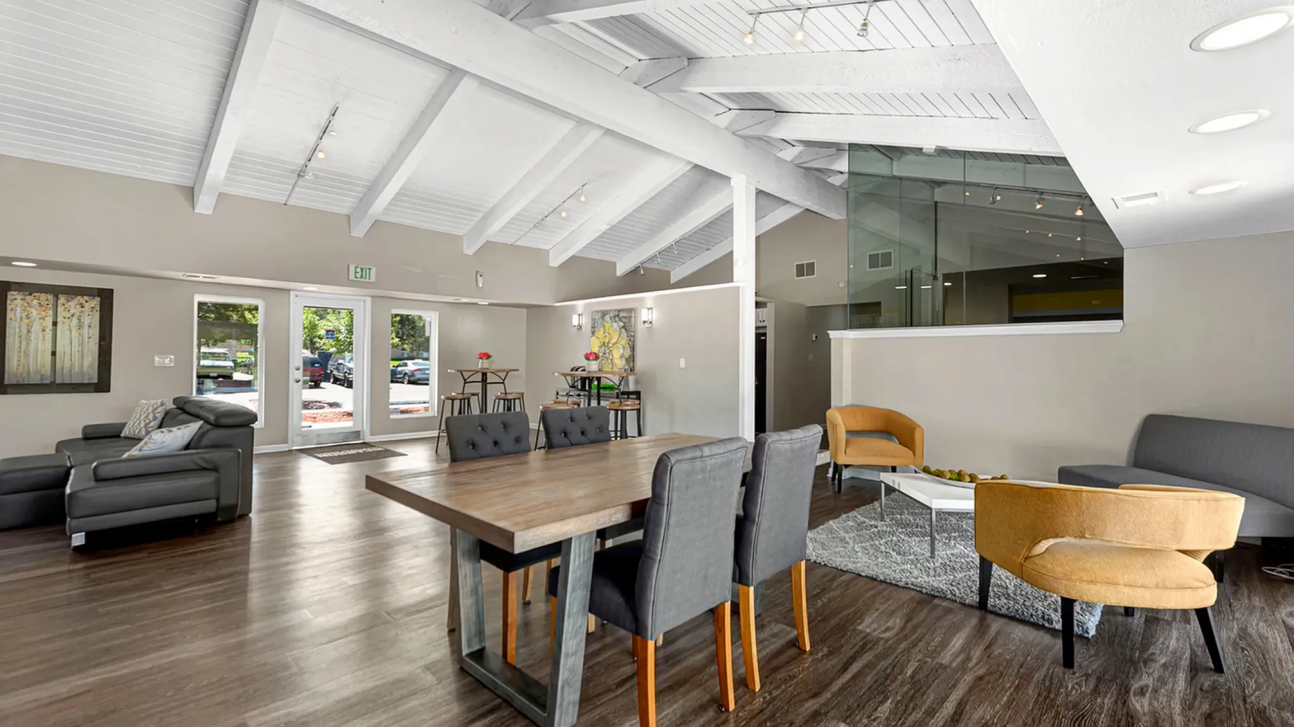 Spacious modern living room with high ceilings, featuring stylish furniture and abundant natural light.