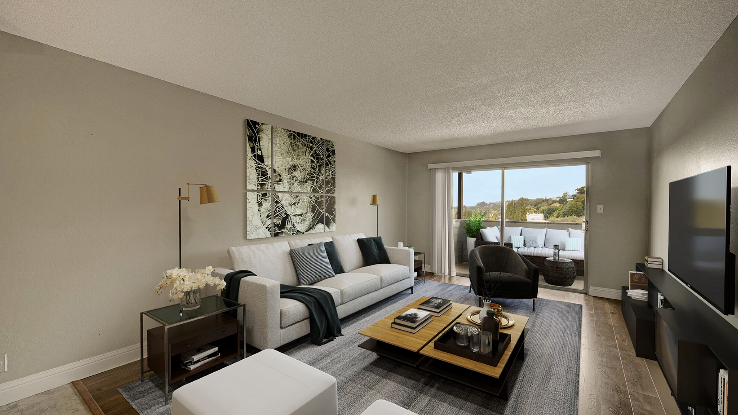 Bright and modern living room with a plush sofa, elegant decor, and a scenic balcony view.