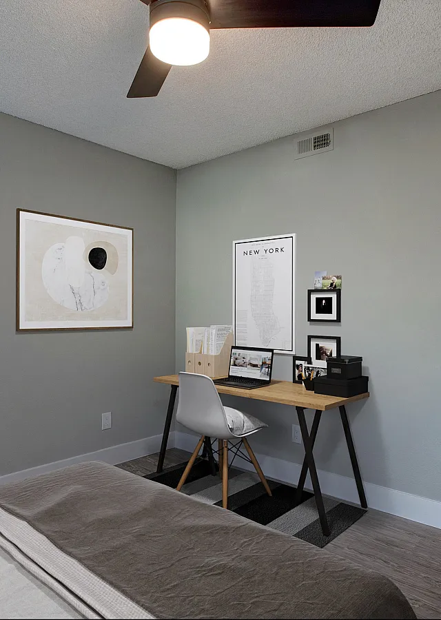 Modern bedroom with sleek desk area, stylish artwork, and a view into a chic bathroom.