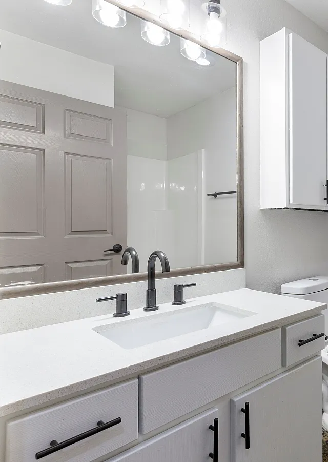 Modern bathroom with sleek fixtures, large mirror, and ample storage in a bright, minimalist design.