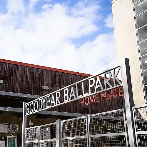 Inviting entrance to Goodyear Ballpark under a bright sky, featuring modern architecture and welcoming ambiance.