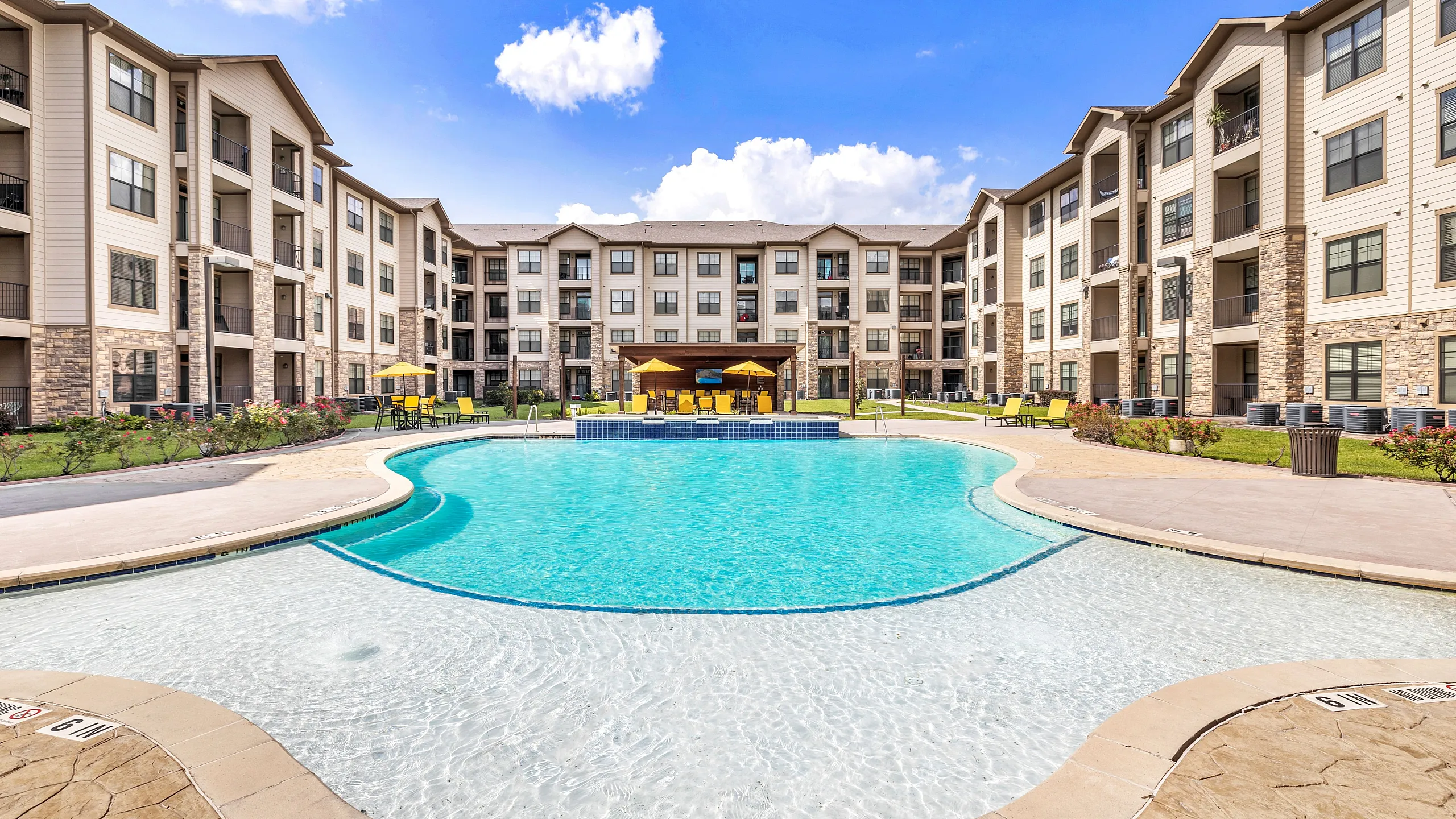 Luxurious apartment complex with elegant architecture and a sparkling resort-style pool, perfect for relaxation and enjoyment.