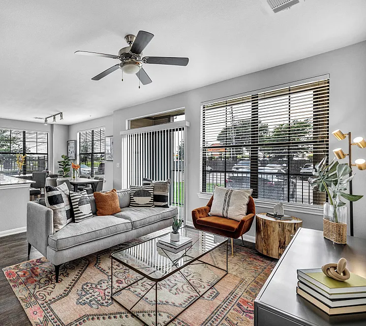 Bright and elegant open-concept living area with stylish furniture, modern kitchen, and large windows offering abundant natural light.