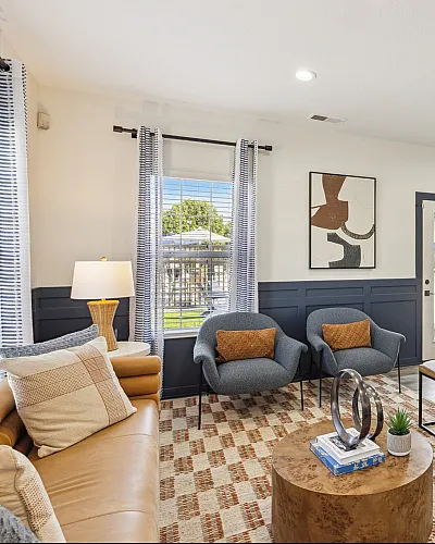 Bright and inviting living room featuring modern decor, cozy seating areas, and large windows filling the space with natural light.