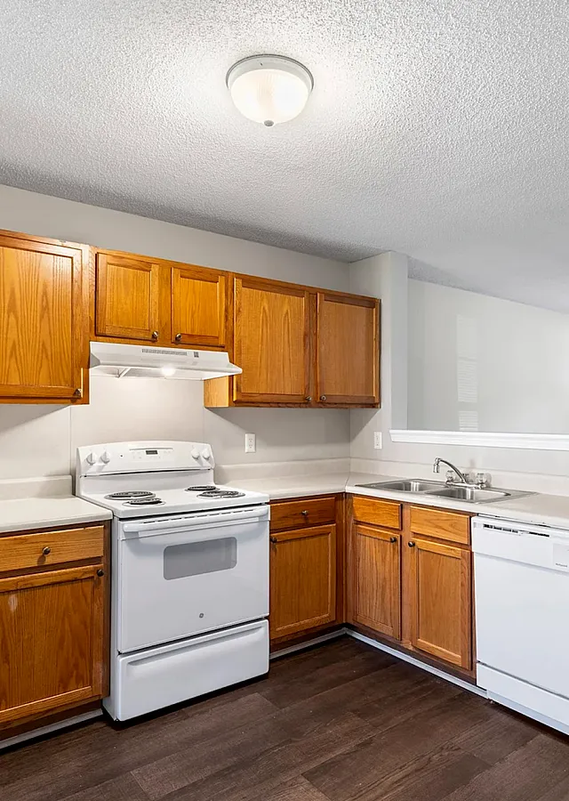 Bright and welcoming kitchen with modern appliances, wooden cabinetry, and spacious countertops, perfect for culinary creativity.